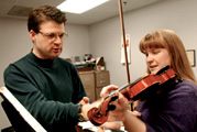 Student receiving violin instruction
