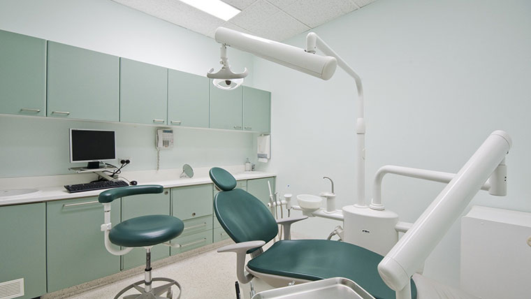 Dental office set up with chair and overhead light.