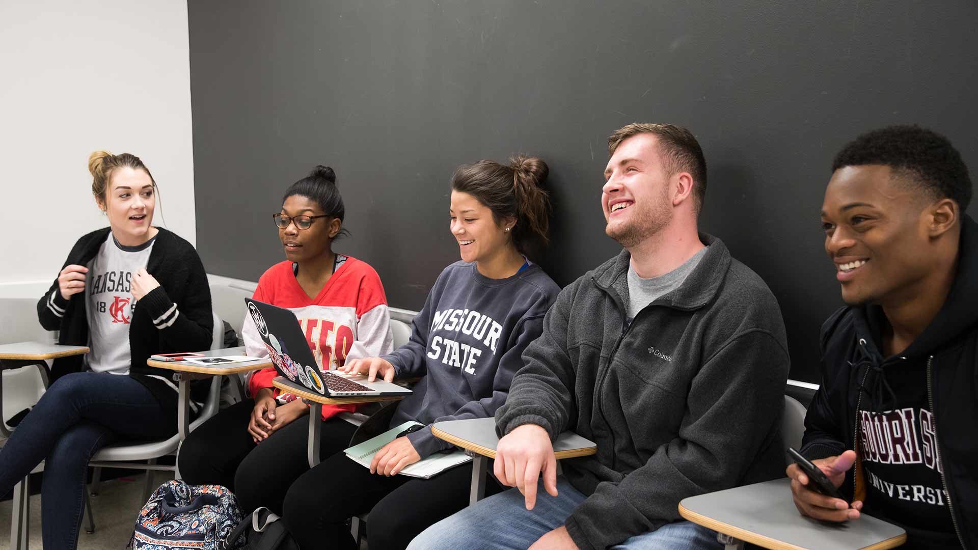 A group of students share a laugh during class.