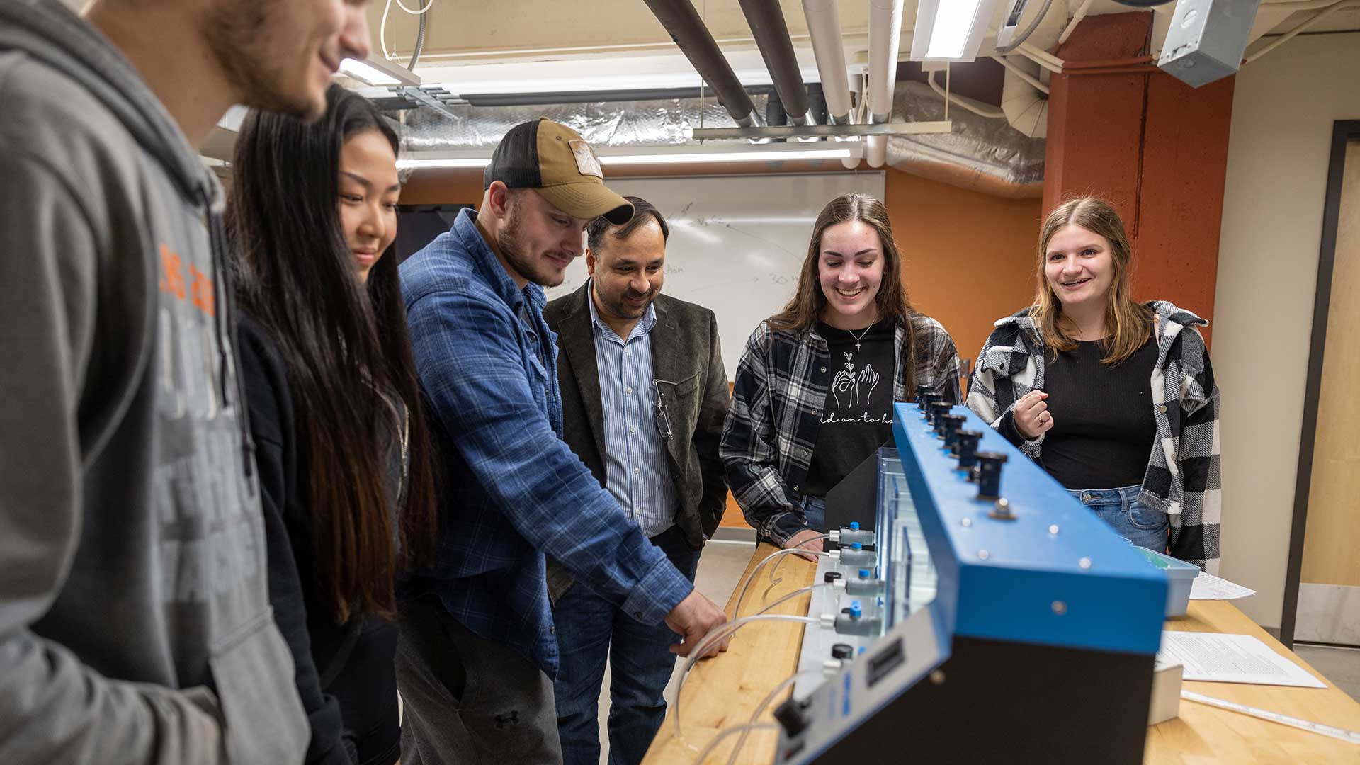 Dr. Sanjay Tewari and a group of students working with water during an environmental engineering lab.