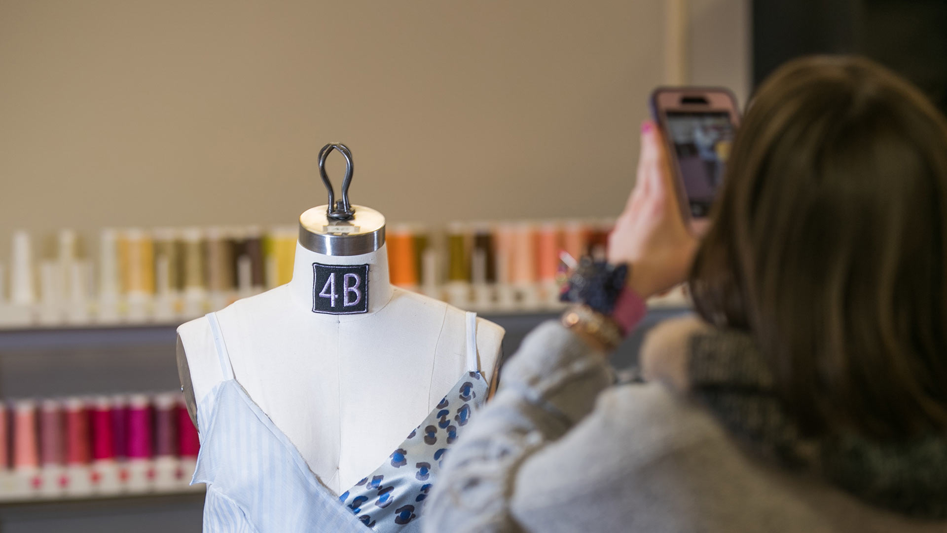 A student uses her photo to take a photo of clothing on a mannequin.