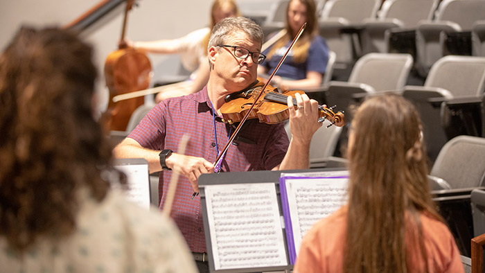 Professor David Hays plays violin for students
