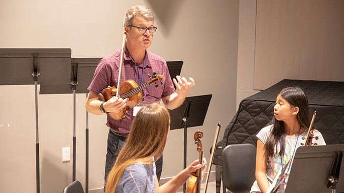 Violin professor David Hays instructs students