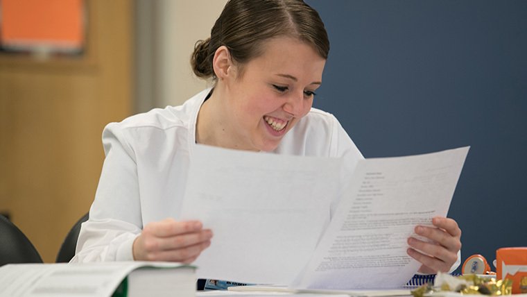 Student smiling at her lab report.