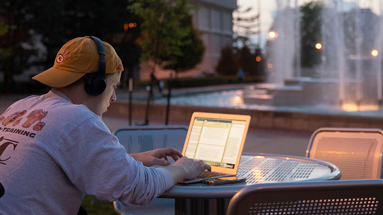 Student studying outside during sunset.