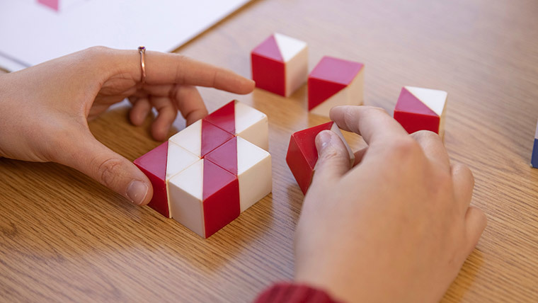 Student organizing red and white cubes,