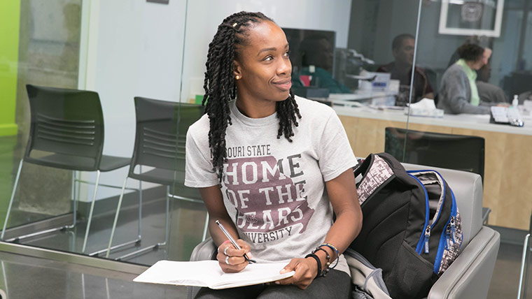 A student taking notes in a study lounge at Pummill Hall.