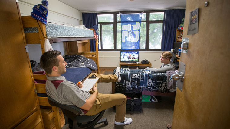 Two students sit in a residence hall room