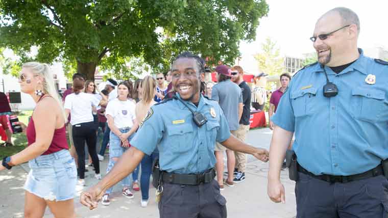 Two officers among a crowd of students at large event