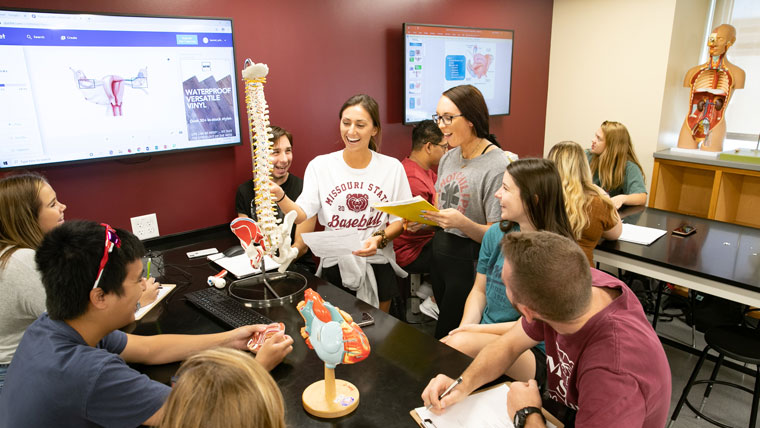 Missouri State students study with their instructor in a lab on campus.