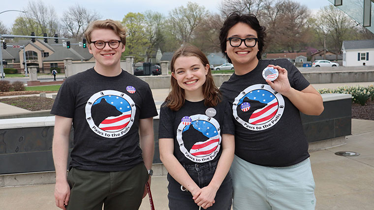 three student members standing together on election day