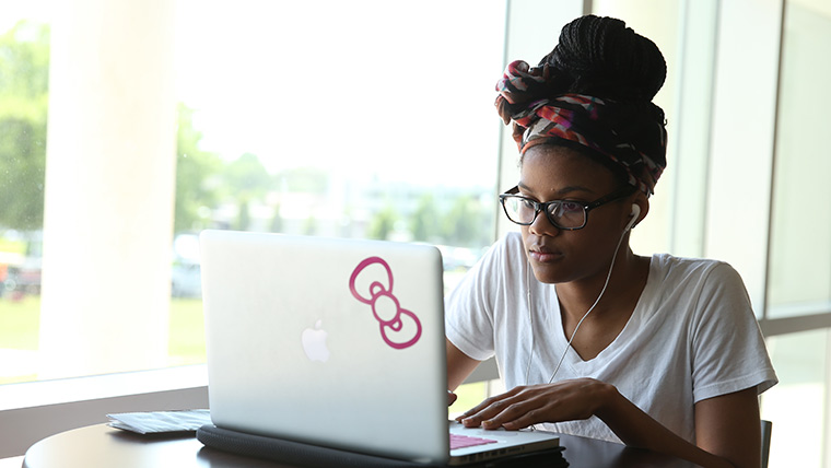 A Missouri State student using her laptop in the Meyer Library.