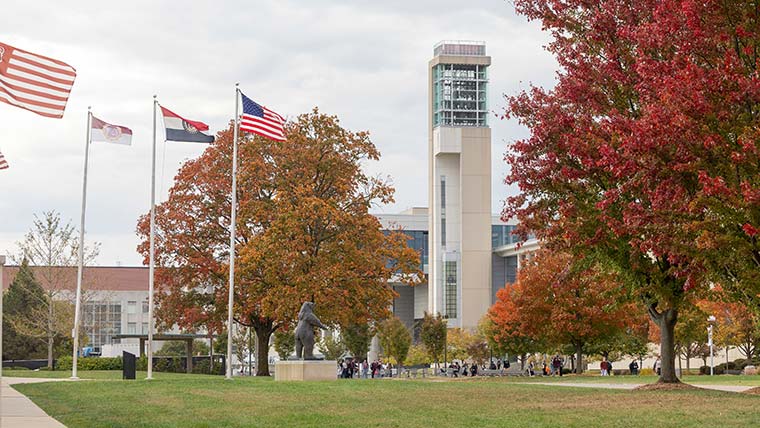Looking west along the west mall, flags fly and the Jane A. Meyer Carillon can be seen.