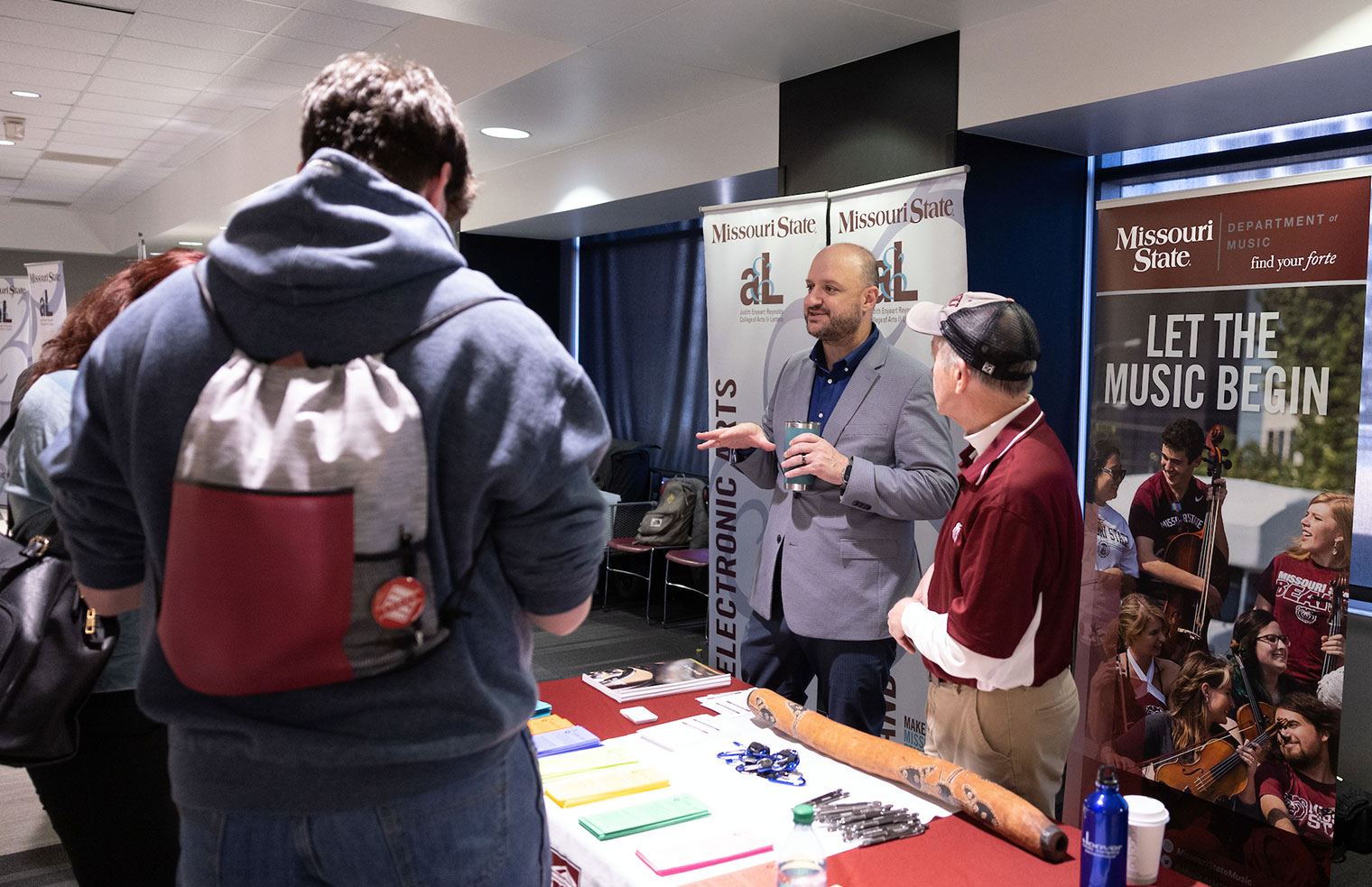 An instructor from the MSU Music programs talks with a visiting family