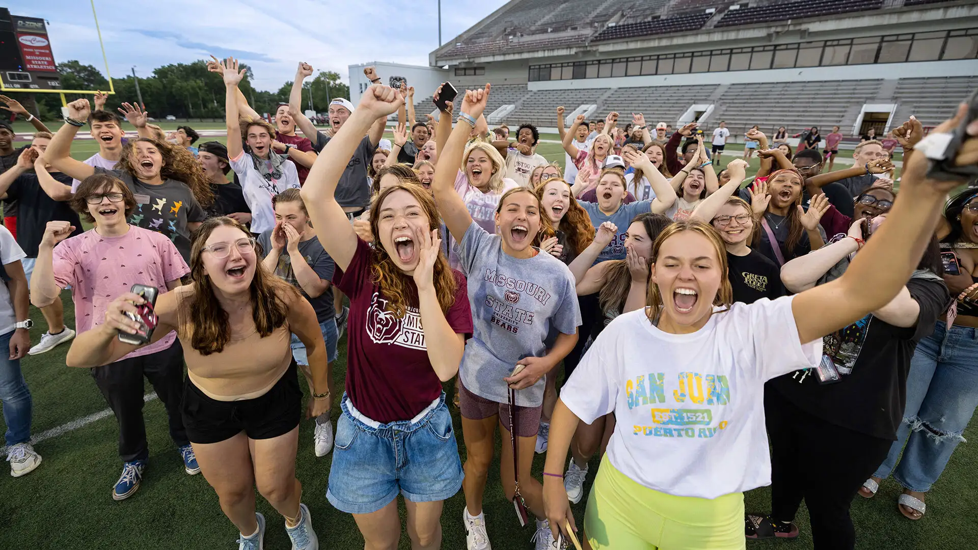 A large group of MSU students cheering inside the football stadium at Playfair during Welcome Weekend