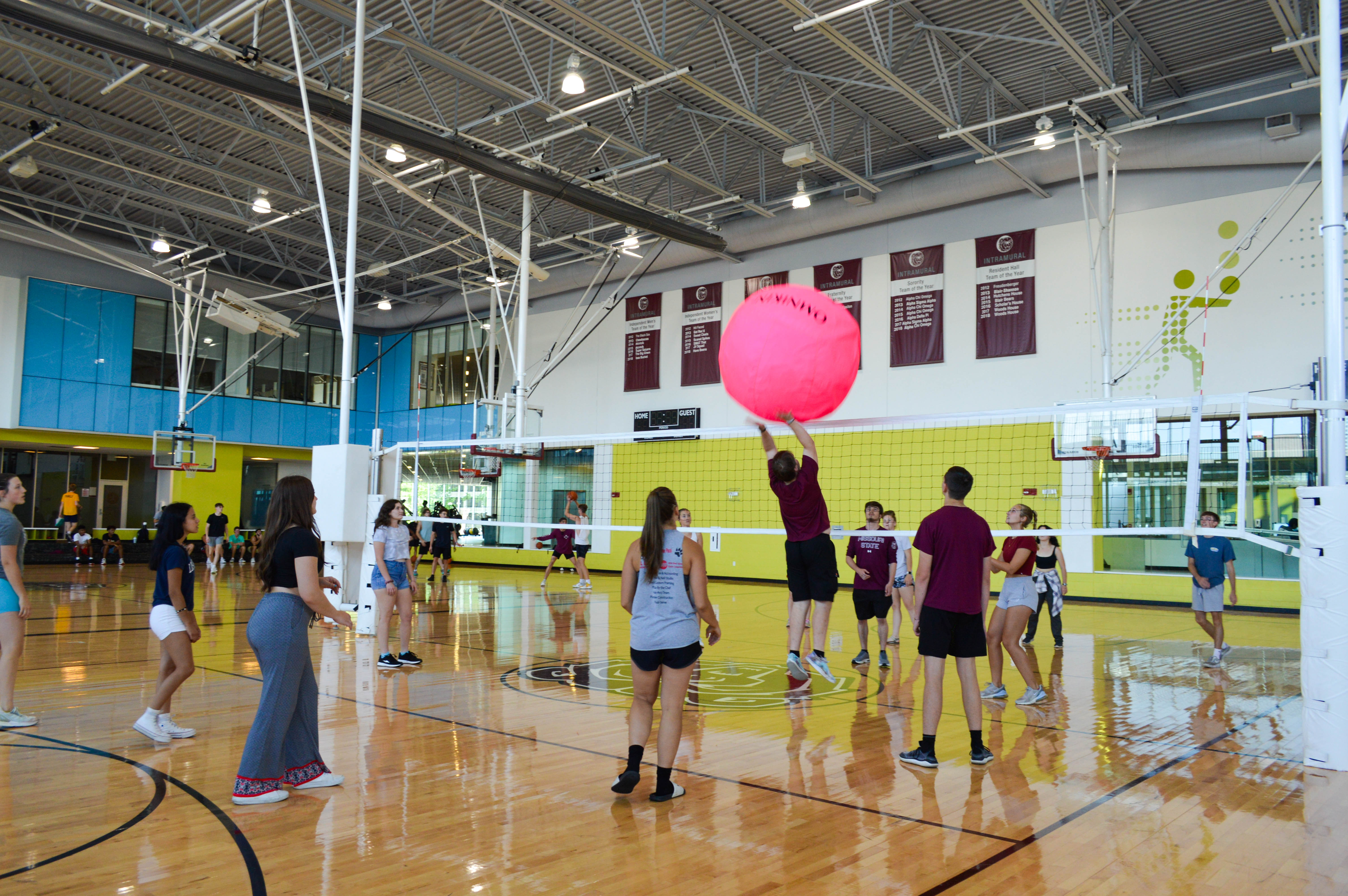 Students playing on indoor volleyball court