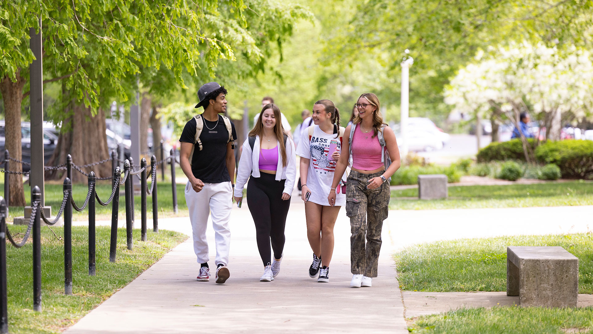 A group of students walking down the sidewalk on campus.