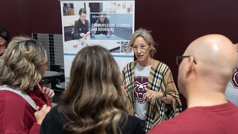 A faculty rep speaking to a student and her parents