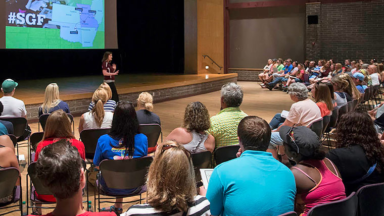 Admission representative giving a presentation in an auditorium for visitors