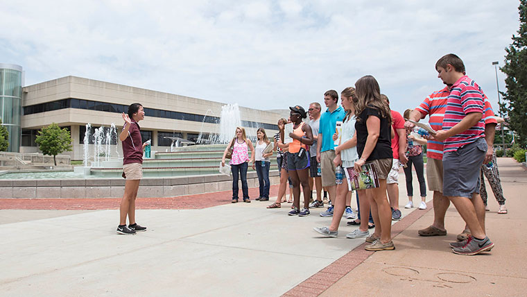 Tour guide leading a group of visitors on campus during Summer Visit Day