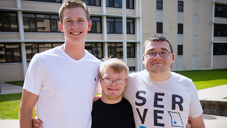 Three smiling Missouri State Bears on the Missouri State campus. 