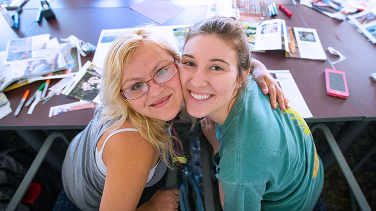 Bear POWER student and her ambassador smiling for the photographer within the classroom. 