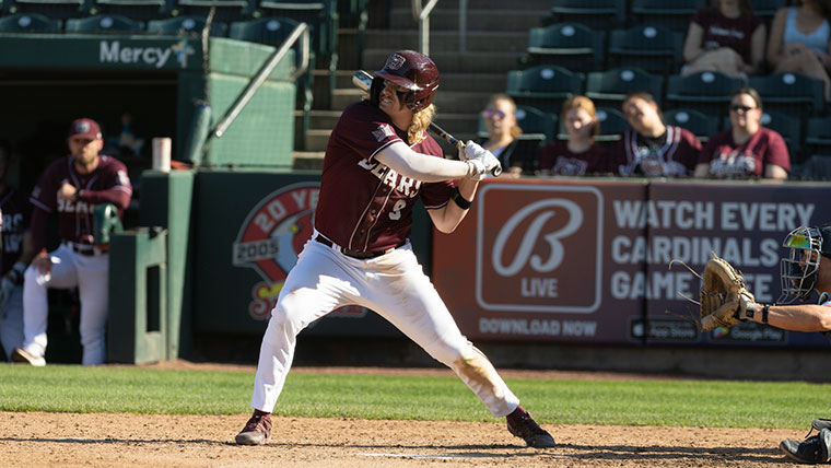 An MSU Baseball player steps up to bat as the audience looks on.