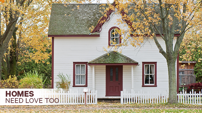 A small, idyllic house with a white picket fence, caption: homes need love too"
