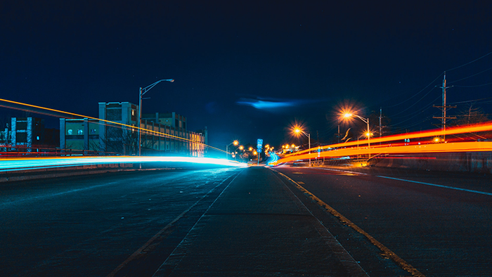 Night time view of road with long exposure of light streaks from traffic