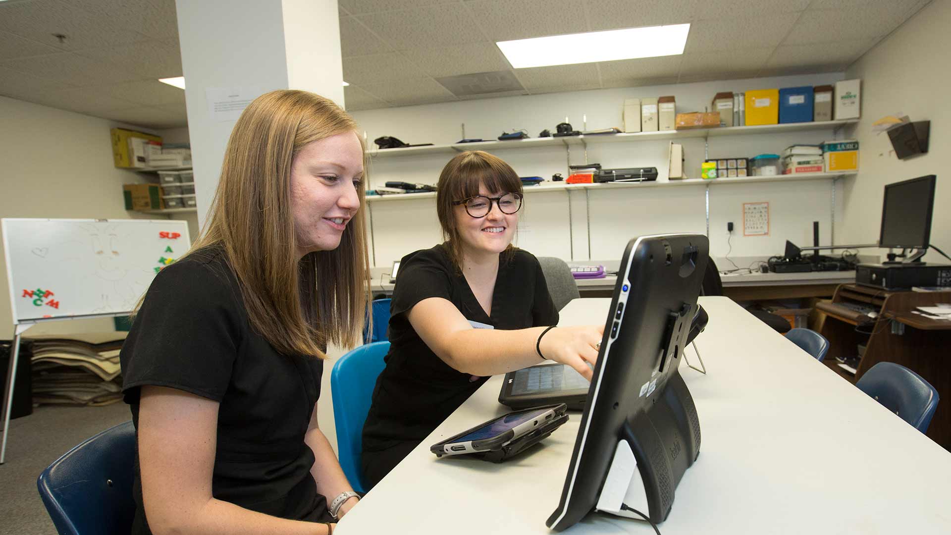 Two speech-language students looking at computer data together.