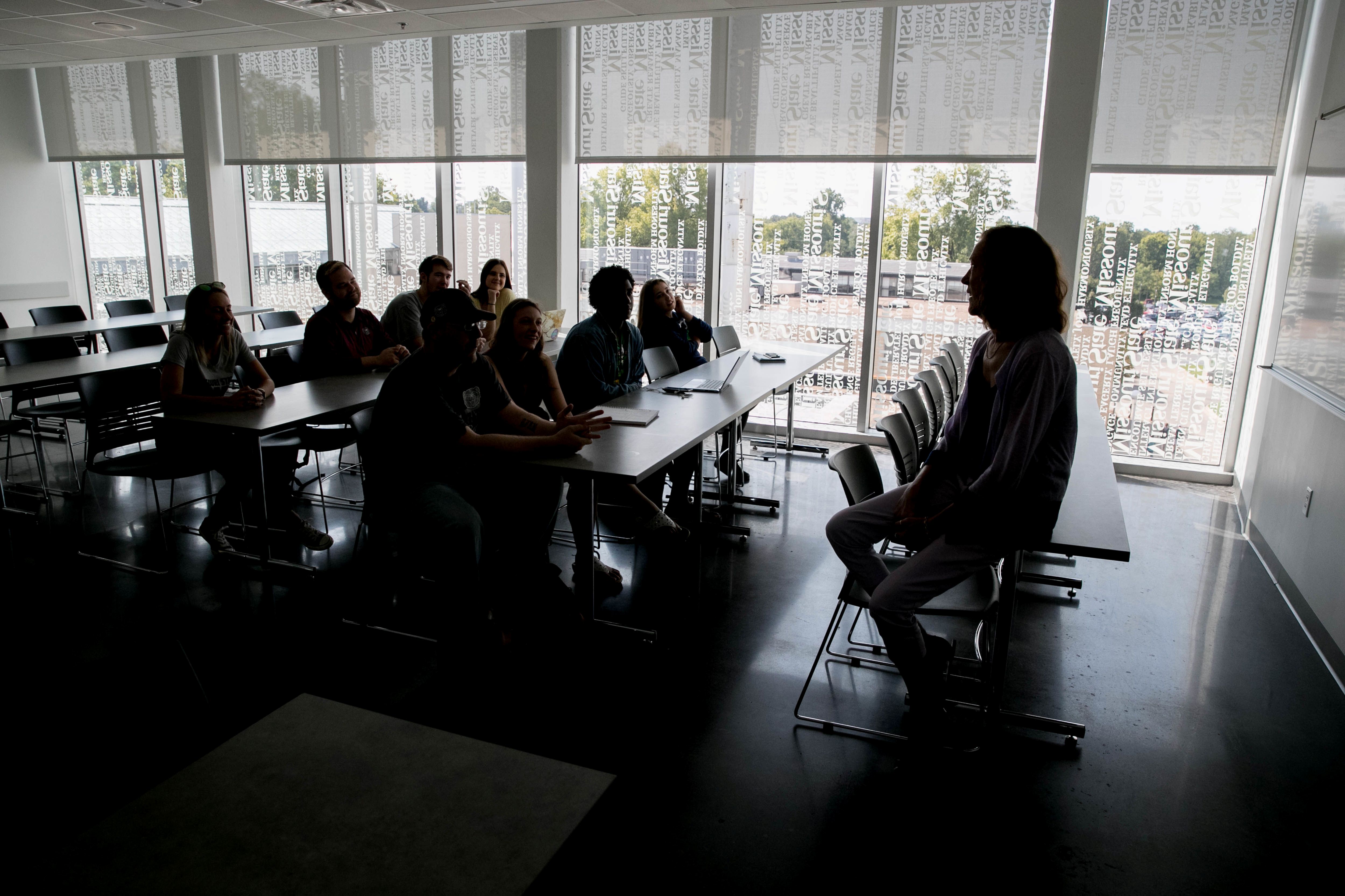 students sitting on rock wall at in the evening 