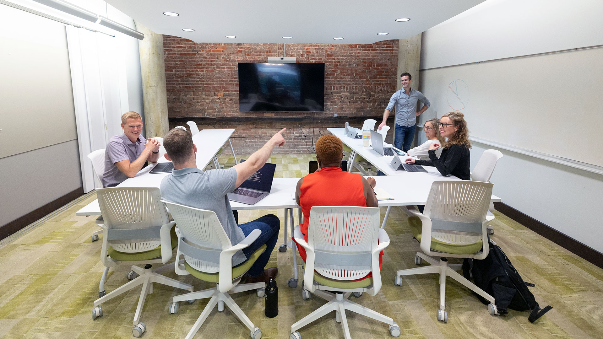 A group of creative thinkers sitting at a conference table discussing a proposed idea. 