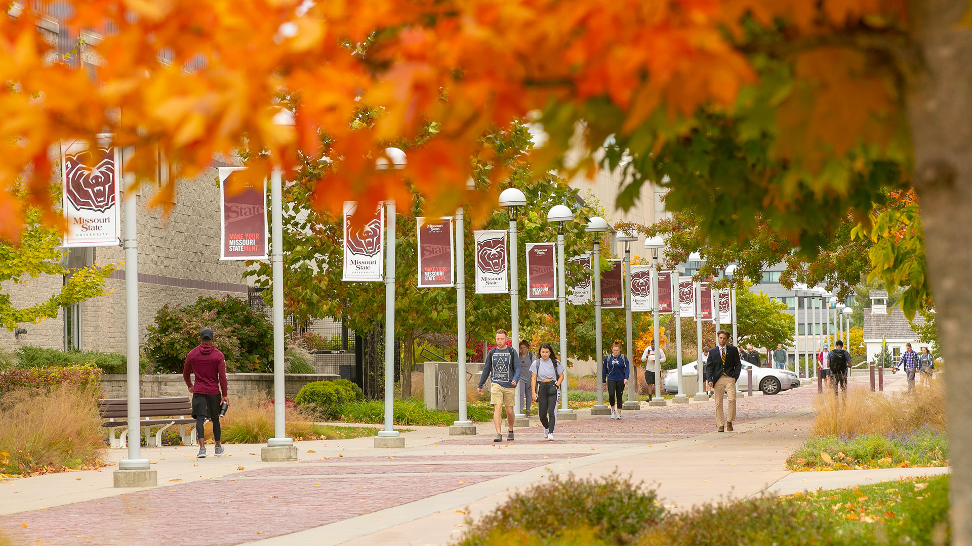 Students walking along brick road on campus Students walking along brick road on campus