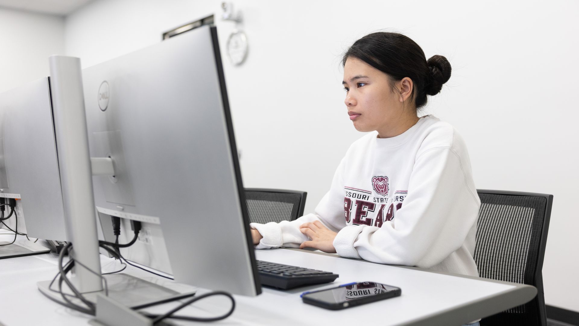 Professor and student looking at information on a laptop.