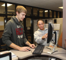 Staff helping a student on a computer