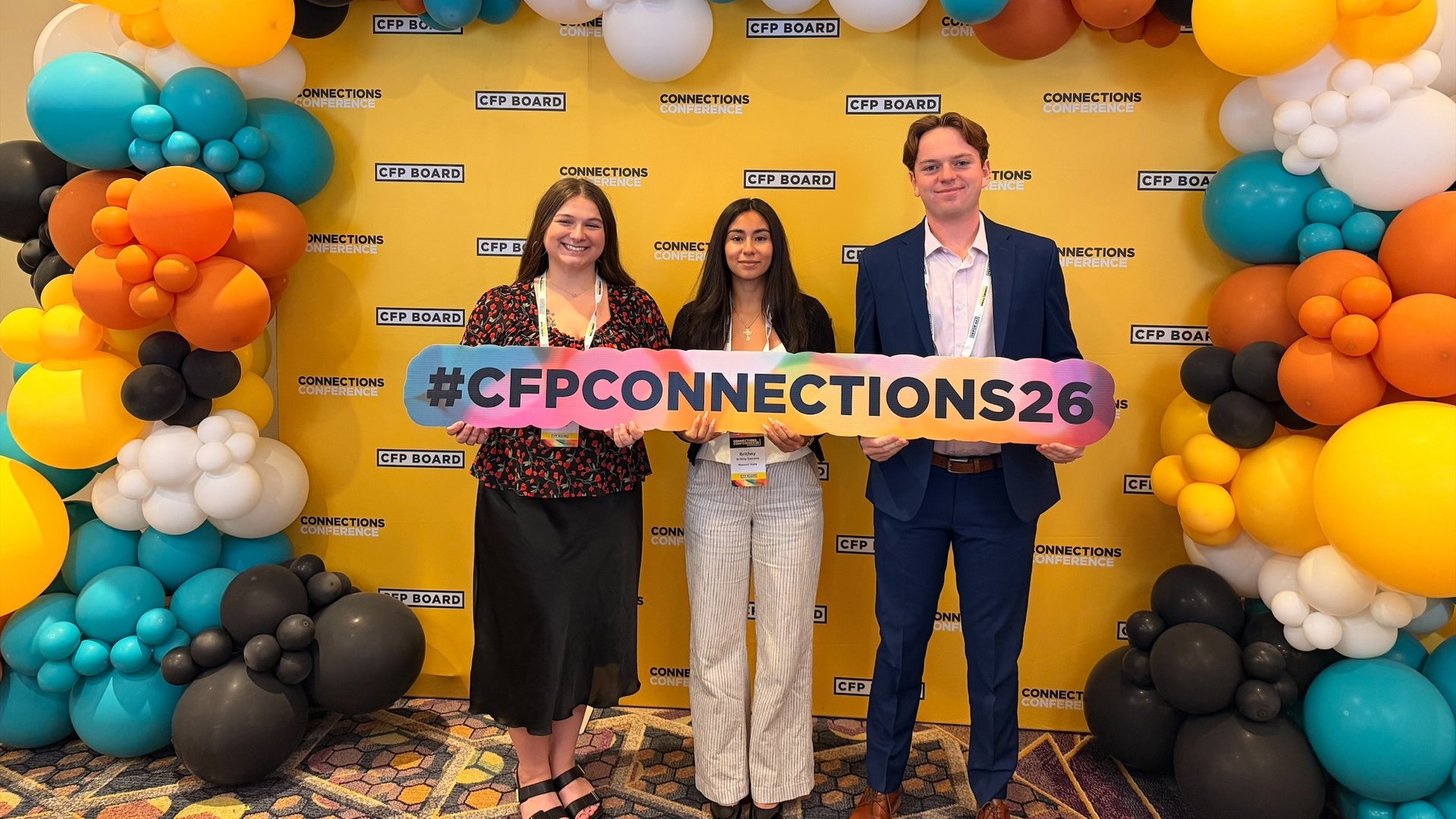Four financial planning students, all wearing Bearwear, hold up a #FutureCFPpro sign
