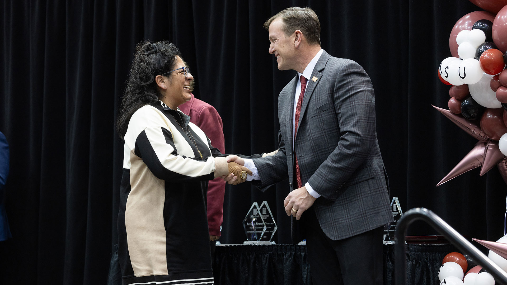 Staff member, Blanca Mallonee, is congratulated by the university president for reaching a length of service milestone.