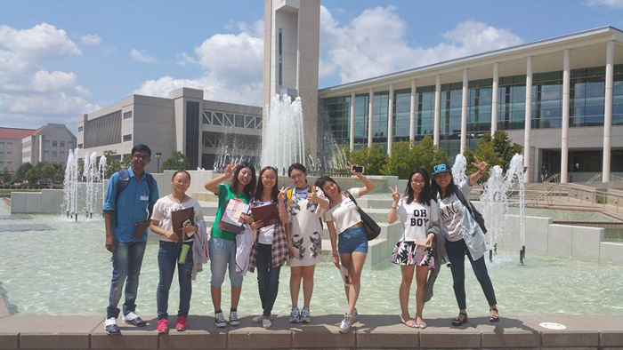 Students are standing infront of long fountain