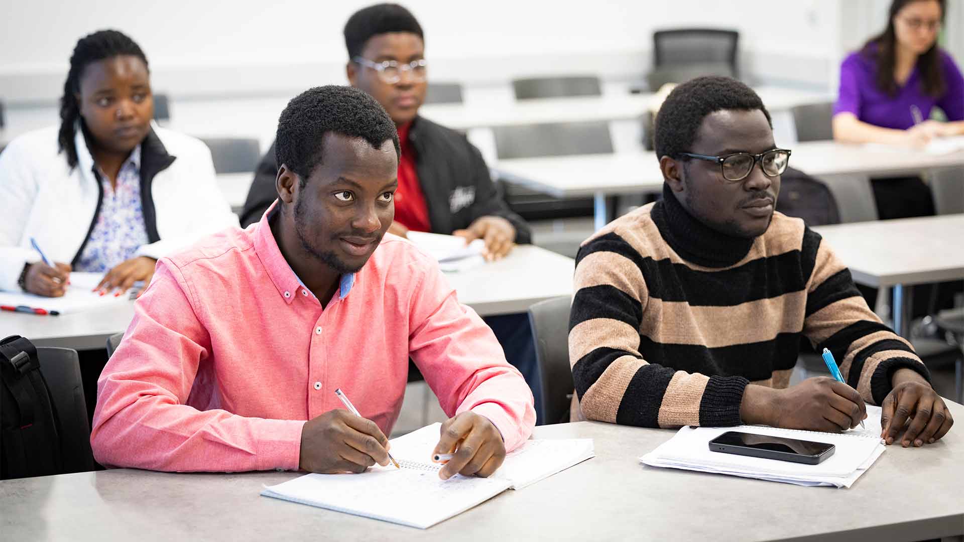 A group of students taking notes attentively during a math class.