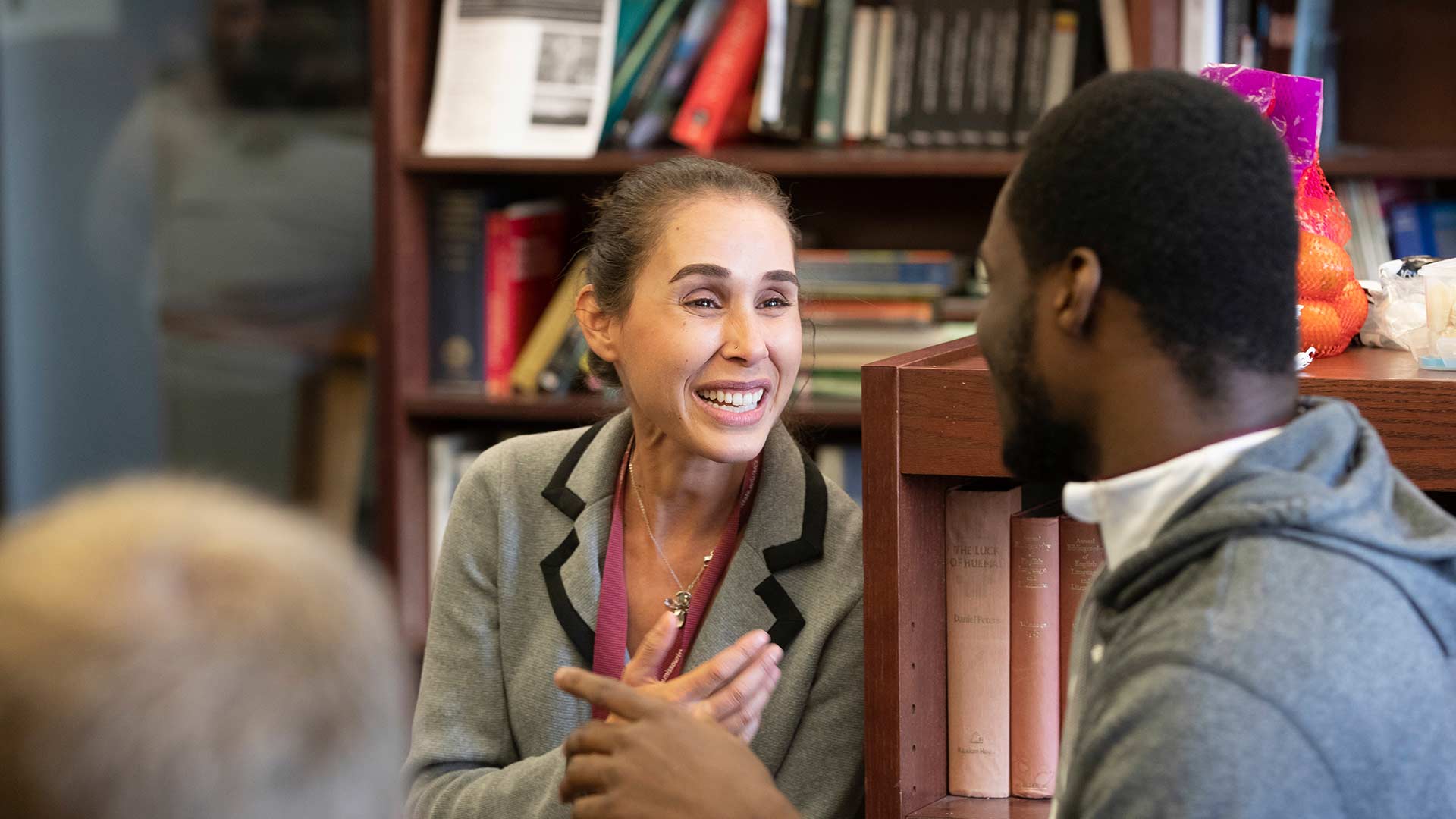 A professor talks to a student during a French club meeting.