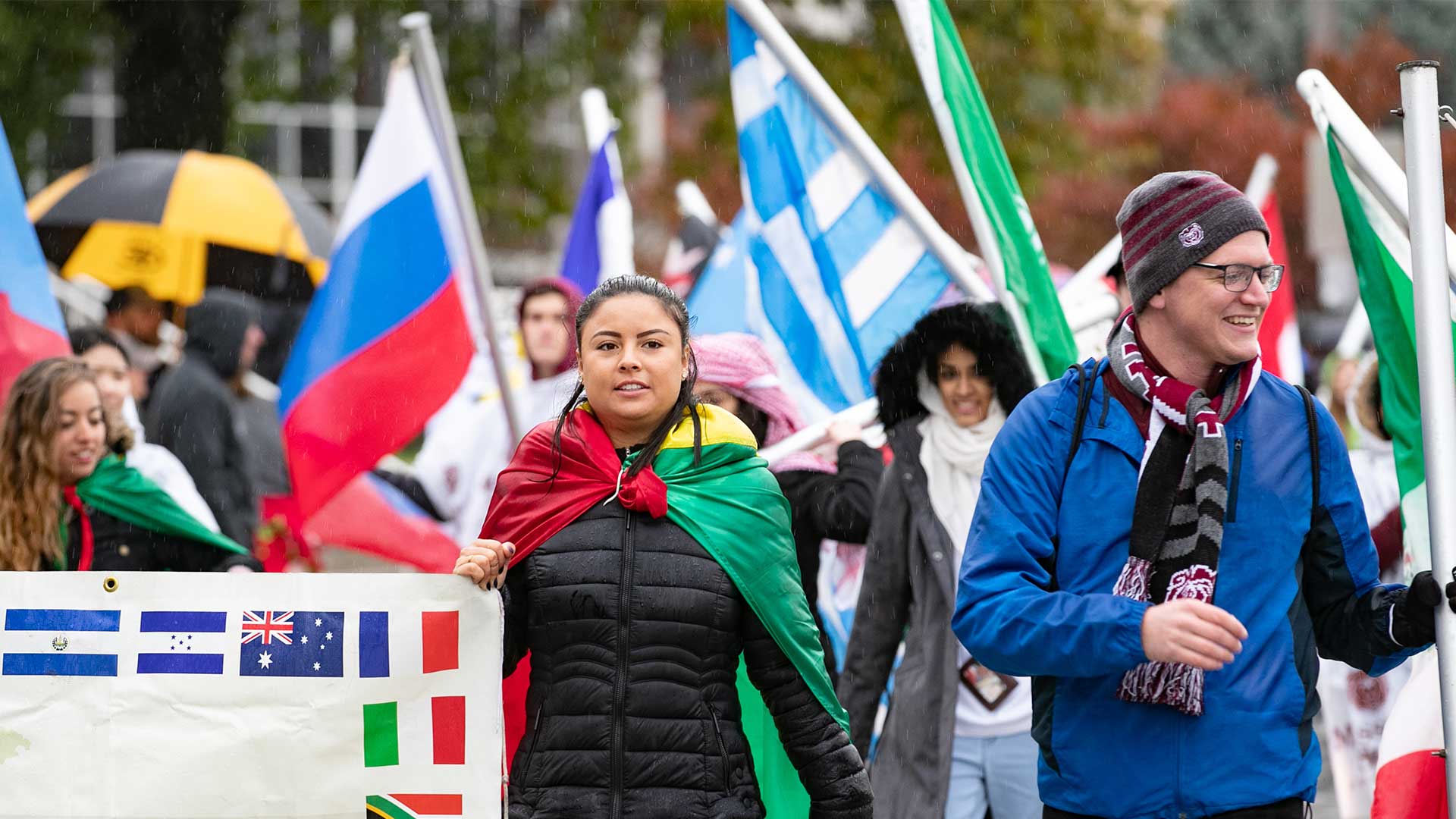 A group of students and faculty from Missouri State international programs march together in a homecoming parade.