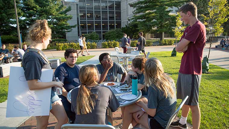 Group of Missouri State students visiting outside on campus. 