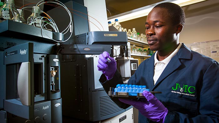 Graduate student Geoffrey Manani using lab equipment to identify compounds