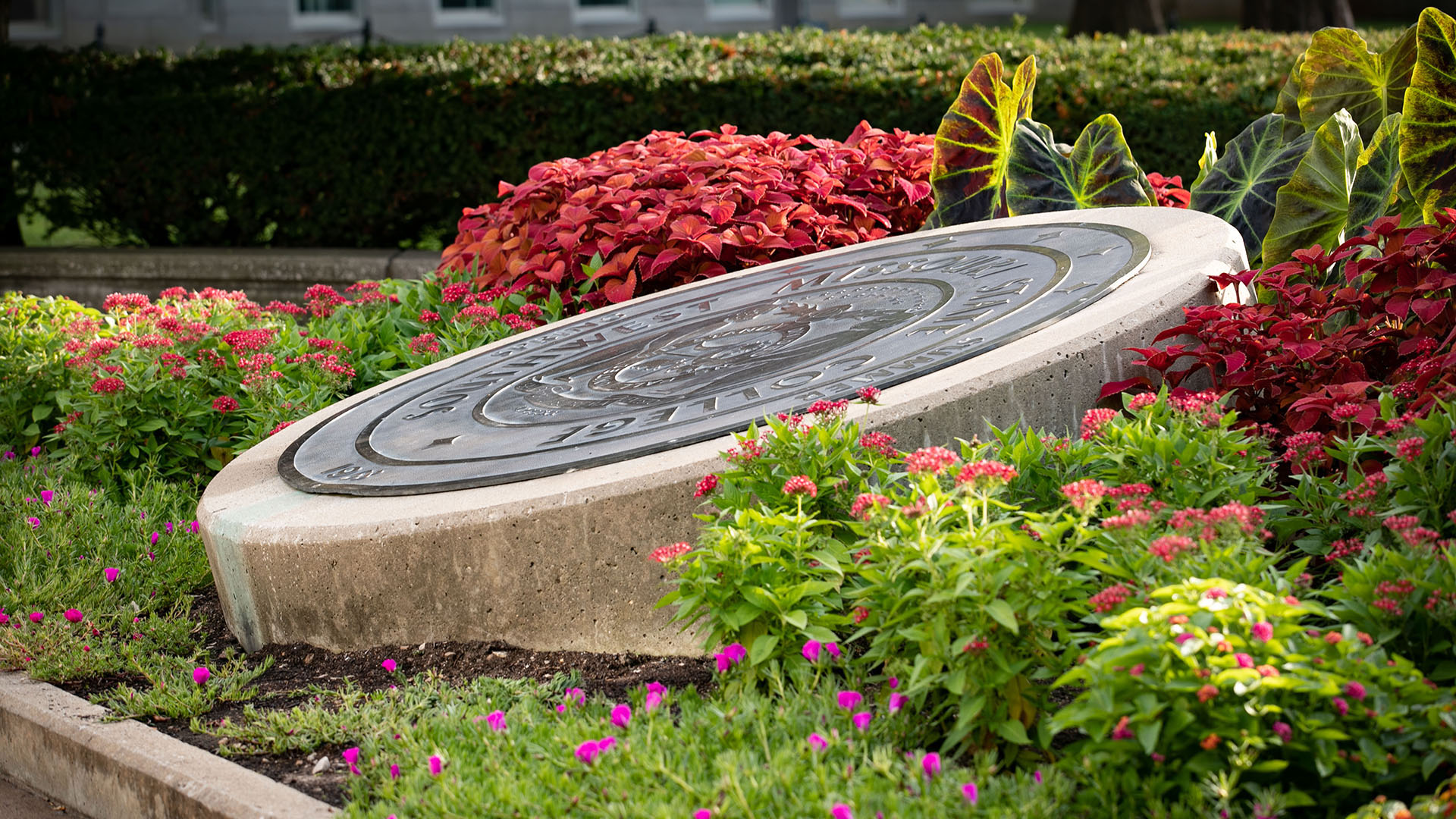 University seal with spring foliage