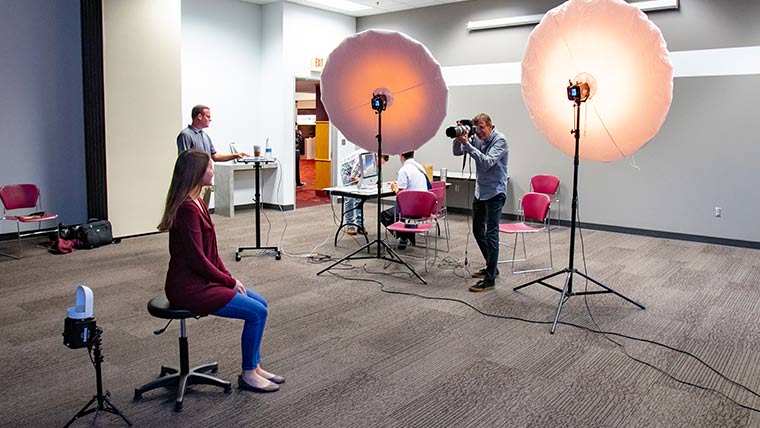 Attendee having her photo taken at Free Portrait Day.