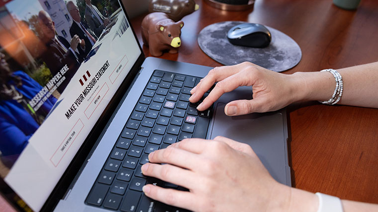 Someone uses a laptop to search the Missouri State website.