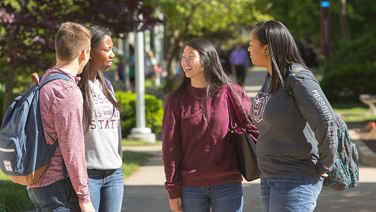Four students stop to chat on the Missouri State campus.