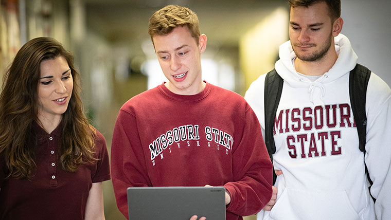 A Missouri State student holds a tablet for his two peers to see.