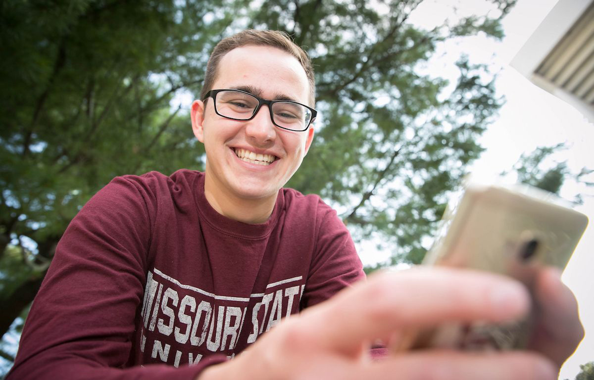 A student looking at his mobile phone.