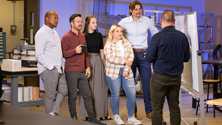 Professionals analyze a white board at the efactory during a presentation.